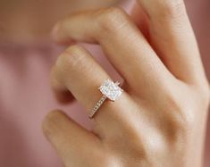 a woman's hand with a diamond ring on it