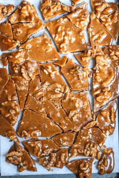 caramel pretzels cut into squares on a sheet of parchment paper with peanut butter