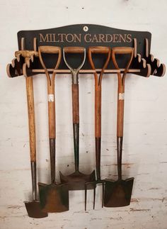 there are many garden tools hanging on the wall