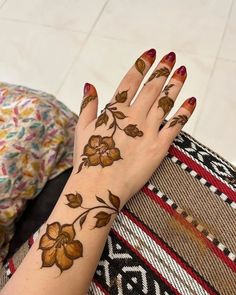 a woman's hand with hendix on it and flowers painted on the arm