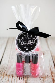 three bottles of nail polish in a clear bag with a black ribbon on the top