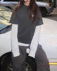 a woman standing in front of a white car