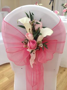 a chair with pink sash and flowers on it