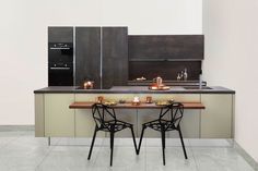 two black chairs sitting at a table in a kitchen