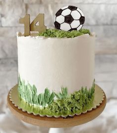 a white cake with green grass and a soccer ball on top that says 4x4