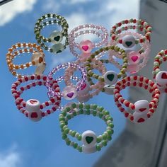 a bunch of bracelets hanging from the side of a car window in front of a blue sky