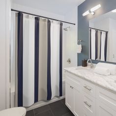 a white and blue bathroom with shower curtain