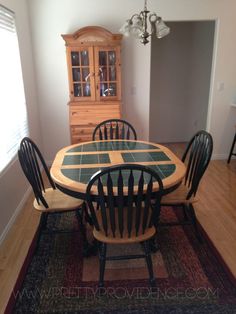 a dinning room table with chairs and a china cabinet in the backround