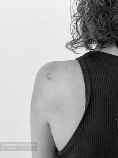 black and white photograph of a woman's back shoulder with the moon tattoo on it