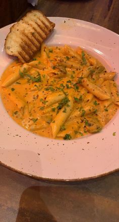 a white plate topped with pasta and bread