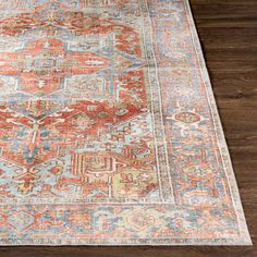 an orange and blue rug on a wooden floor with a wood floor in the background