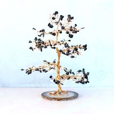 a small tree with lots of black and white leaves