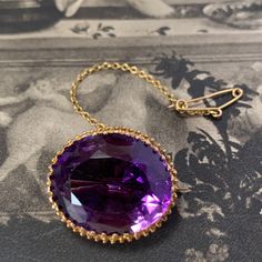 a stunning piece of late 19th to turn-of-the-century late Victorian jewelry. It features a rich purple amethyst set within a high carat gold pierced and scrolled setting. The brooch is in excellent condition and its lack of maker's marks or gold marks is not unusual for antique pieces. The brooch's design includes a gold safety chain for added security, and the amethyst itself is in pristine condition, free from any nibbles or scratches. The stone is a mixed cut, with a generous faceted crown an Amethyst Set, Rich Purple, Antique Boxes, Safety Chain, Victorian Jewelry, Gold Set, Amethyst Gemstone, Gold Platinum, Purple Amethyst