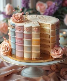 a cake decorated with books and flowers on a table next to some pink rose petals