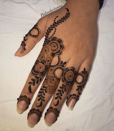 a woman's hand with henna tattoos on it