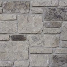 a stone wall made out of several different types of stones, including gray and white