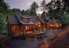 a large house in the woods with lots of windows and lights on it's roof