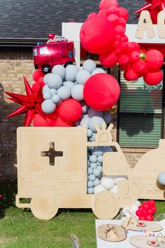 a table with balloons and decorations on it in front of a house that is decorated for a birthday party