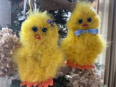 two yellow chicks sitting on top of a christmas tree