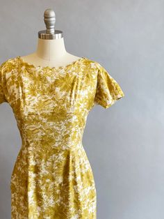 "1950s cotton sateen very fitted day dress. Ivory ground with an all over mustard brush stroke floral print. The neckline is pointed scallops. Top-stitched seams across the bodice, as well as form fitting vertical seams front and back. Cap sleeves, a V-back, with a metal zipper and hook and eye closure. Size- Small Bust - 34\" Waist - 27\" Hips - 39\" Length - 39\" Label: Janice Jr. Condition: Excellent vintage condition. All vintage is sold in \"as-is\" condition. We do our best to inspect, cor Yellow Fitted Dress In 1950s Style, Fitted Yellow Dress In 1950s Style, Mustard Fitted Floral Print Dress, Fitted Mustard Floral Print Dress, Mustard Fitted Cotton Dress, Fitted Mustard Cotton Dress, Fitted Vintage Mustard Dress, Fitted Yellow 1950s Dresses, Fitted Mid-century Yellow Dress