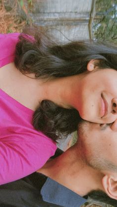 a man and woman laying on the ground next to each other with their eyes closed