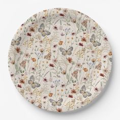 a white plate with flowers and butterflies on it