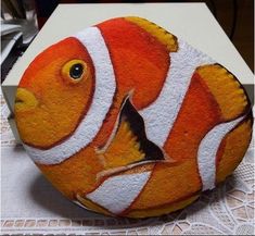 an orange and white painted rock sitting on top of a table