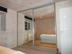 an empty room with a bed and sliding glass doors