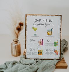 a bar menu sitting on top of a table next to a vase with dry grass