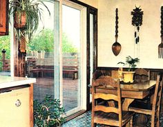 a dining room table and chairs in front of sliding glass doors