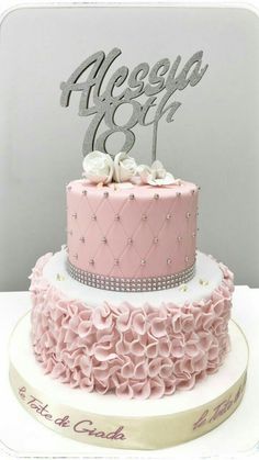 a pink and white cake sitting on top of a table