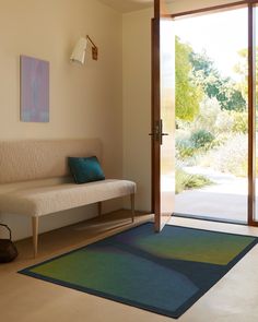 a living room with a couch, rug and sliding glass door