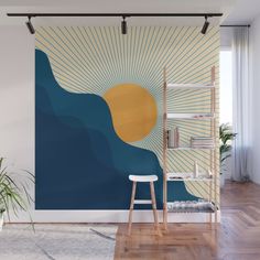 a room with a large wall mural in the shape of a sun and ocean waves