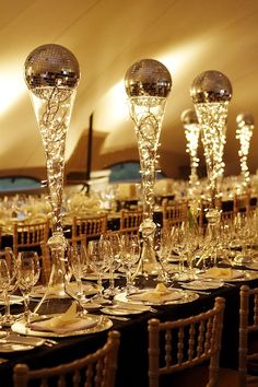 the tables are set with wine glasses and place settings for guests to sit down at