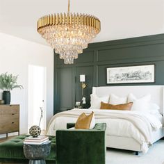 a bedroom with a bed, green chairs and a chandelier hanging from the ceiling