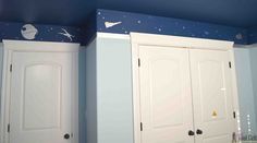 two white closets with space decals on the walls in a blue and white bedroom