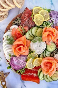 a platter with salmon, cucumbers and other vegetables