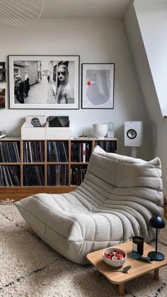 a living room filled with lots of furniture and pictures on the wall above it's bookshelf