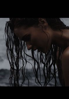 a woman with wet hair standing in the water