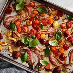 a pan filled with tomatoes and onions on top of a table