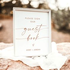 a guest book sitting on top of a rock with the words please sign our guest book