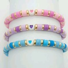 three different colored bracelets with hearts on them