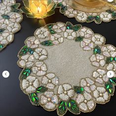 a table topped with lots of green and white doily covered in sequins