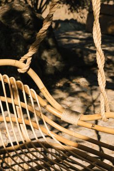 a close up of a wooden swing with rope hanging from it's sides,