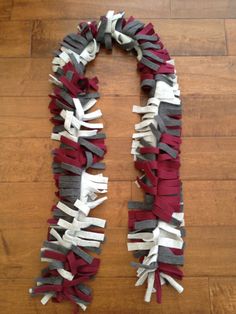 a red and white scarf sitting on top of a wooden floor