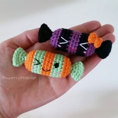 two small crocheted items in the palm of someone's hand, one with a cat on it