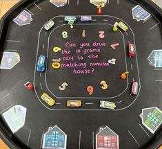 a child's play table with cars and numbers written on the board in pink