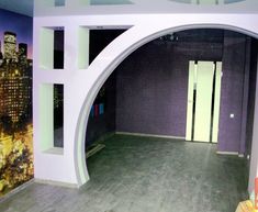 an empty room with purple walls and white arches on the wall, in front of a cityscape