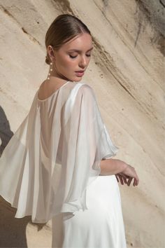 This sheer bridal cape is crafted from luxurious silk chiffon that drapes like a dream. Its magic is in the cascading shape towards the back, making it flow gracefully as you make your entrance. The boat neckline enables you to slide this wedding capelet over your head, allowing for a perfect construction without a single seam. Wedding Dress Cover Up, Bridal Topper, Wedding Dress Cover, Wedding Capelet, Bridal Capelet, Cape Wedding, Cape Designs, Cape Wedding Dress, Wedding Shrug