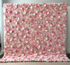 a large pink and white flower covered wall